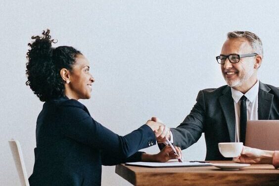 A man and a woman shaking hands after an interview.