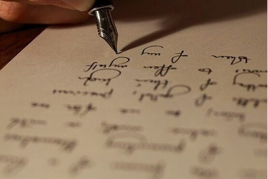 A pen writing on paper without a hand in view